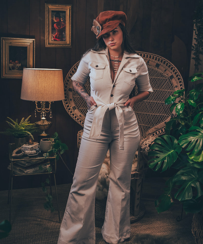 Woman wearing a cream corduroys 70s jumpsuit with flared legs and wrapped her collar handmade by Soul sister since 1969