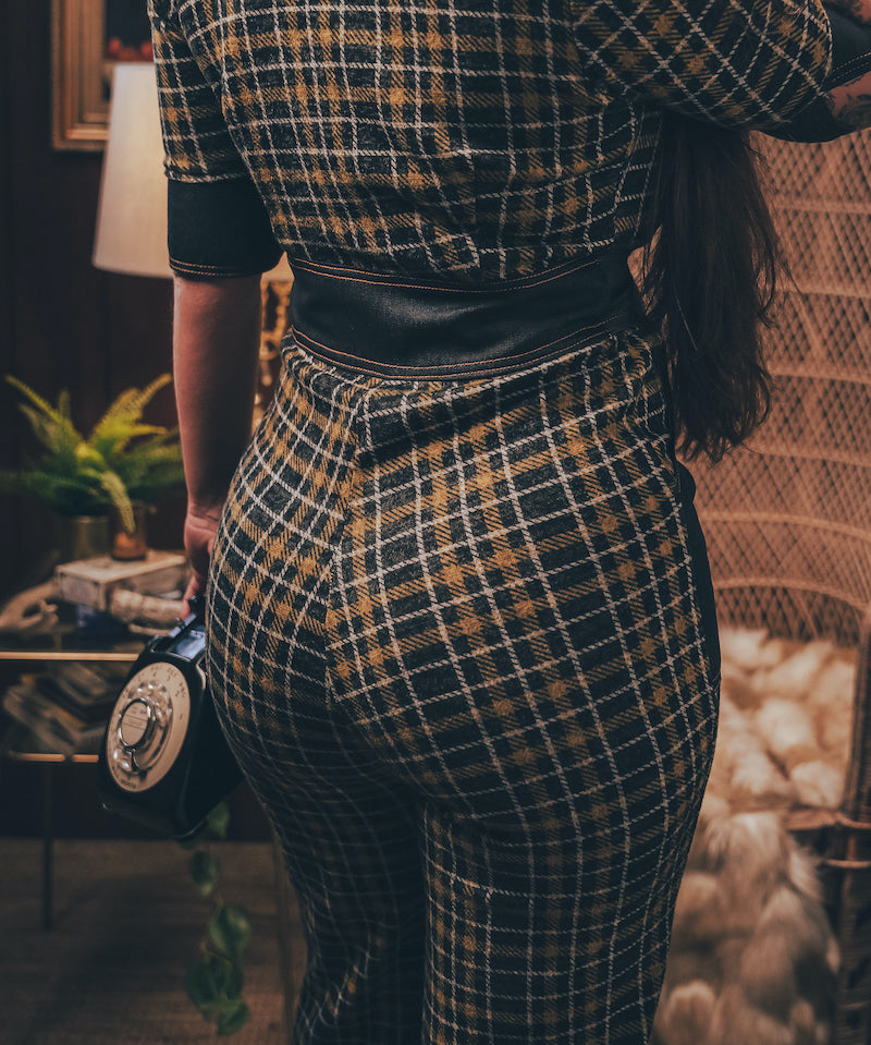 Knit plaid diva jumpsuit with contrasting denim front pockets, collar, and belt, blending retro 70's charm with bold, modern flair.
