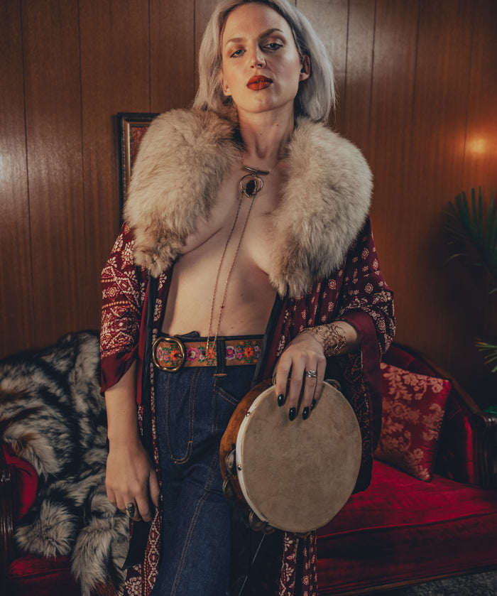 Beautiful woman wears bell bottom jeans in a 1970s retro living room
