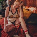 Woman in a soulful log  jersey sitting on a couch with a retro phone and plant in the background