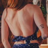 Person wearing a blue dress with star patterns, standing indoors.