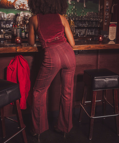 Person wearing a red jumpsuit in a bar setting