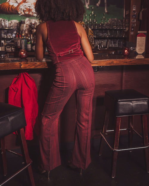 Person wearing a red jumpsuit in a bar setting