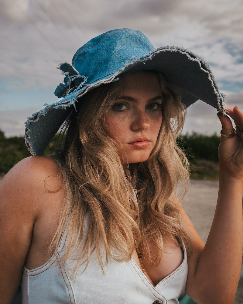 Woman wearing a blue denim hat outdoors with a natural background Wearing Soul Sister since 1969