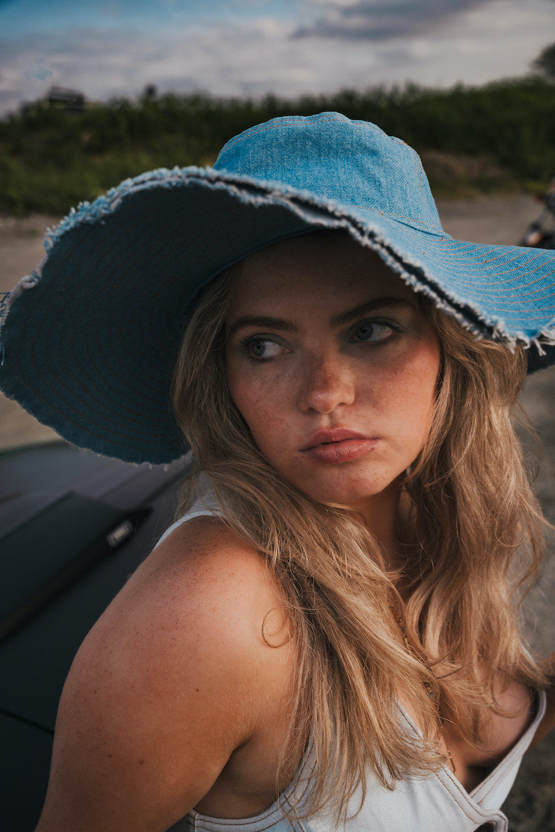 Woman wearing a blue sun hat  by Soul Sister since 1969 with a blurred background