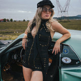 Woman in a black outfit and sunglasses leaning against a vintage car with power lines in the background wearing Soul Sister since 1969.
