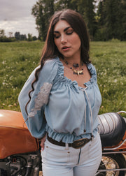 Woman standing next to a motorcycle in a field wearing Soul Sister since 1969