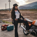 Woman in a desert setting with a motorcycle and suitcases, wearing a 'Ride or Die' t-shirt designed and made by Soul Sister since 1969.