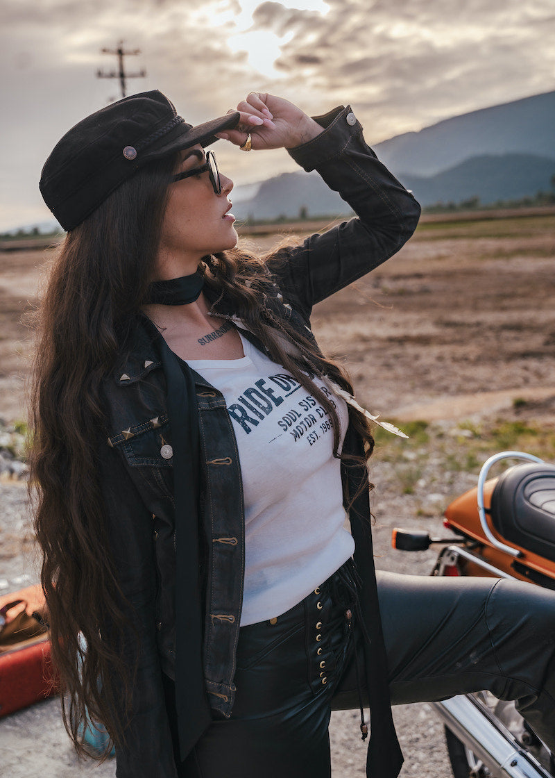 Woman with long hair and a hat standing outdoors with mountains in the background wearing Soul Sister since 1969