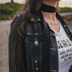 Person wearing a black denim jacket and white graphic t-shirt with text wearing Soul Sister since 1969.