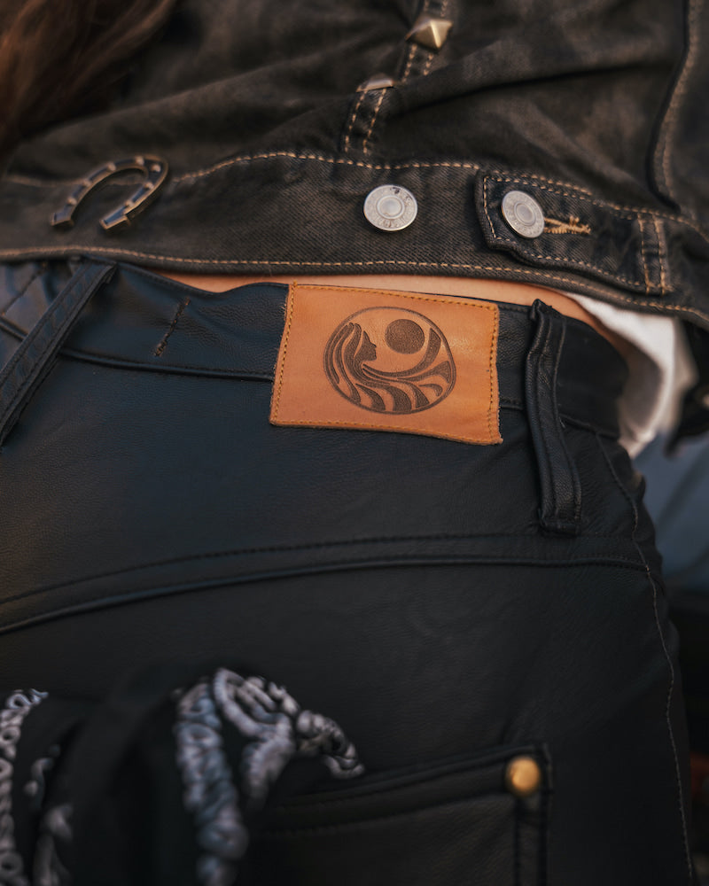 Close-up of a dark jacket with a leather patch featuring a logo  Soul Sister since 1969.