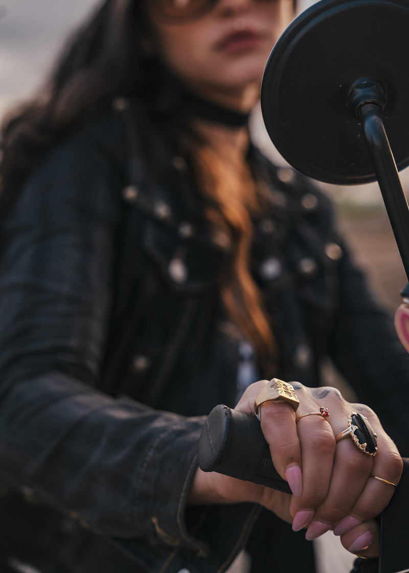 Person wearing multiple rings on a motorcycle, with a microphone close-up wearing Soul Sister since 1969.