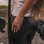 Person wearing black pants with a focus on their hand and jewelry wearing clothing designed and made by Soul Sister since 1969.