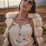 Woman wearing sunglasses and a fur vest in a desert landscape wearing soul sister since 1969