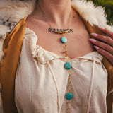 Person wearing a necklace with turquoise stones and a tattoo on their chest wearing soul sister since 1969.