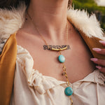 Necklace with turquoise stones and gold chain worn by a person outdoors wearing soul sister since 1969