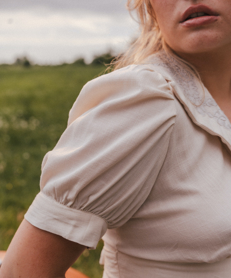 Woman wearing a beige blouse with puffed sleeves in a natural setting wearing Soul Sister since 1969