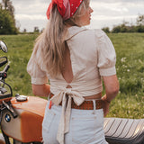 Woman with a red bandana standing next to a motorcycle in a field wearing Soul Sister since 1969